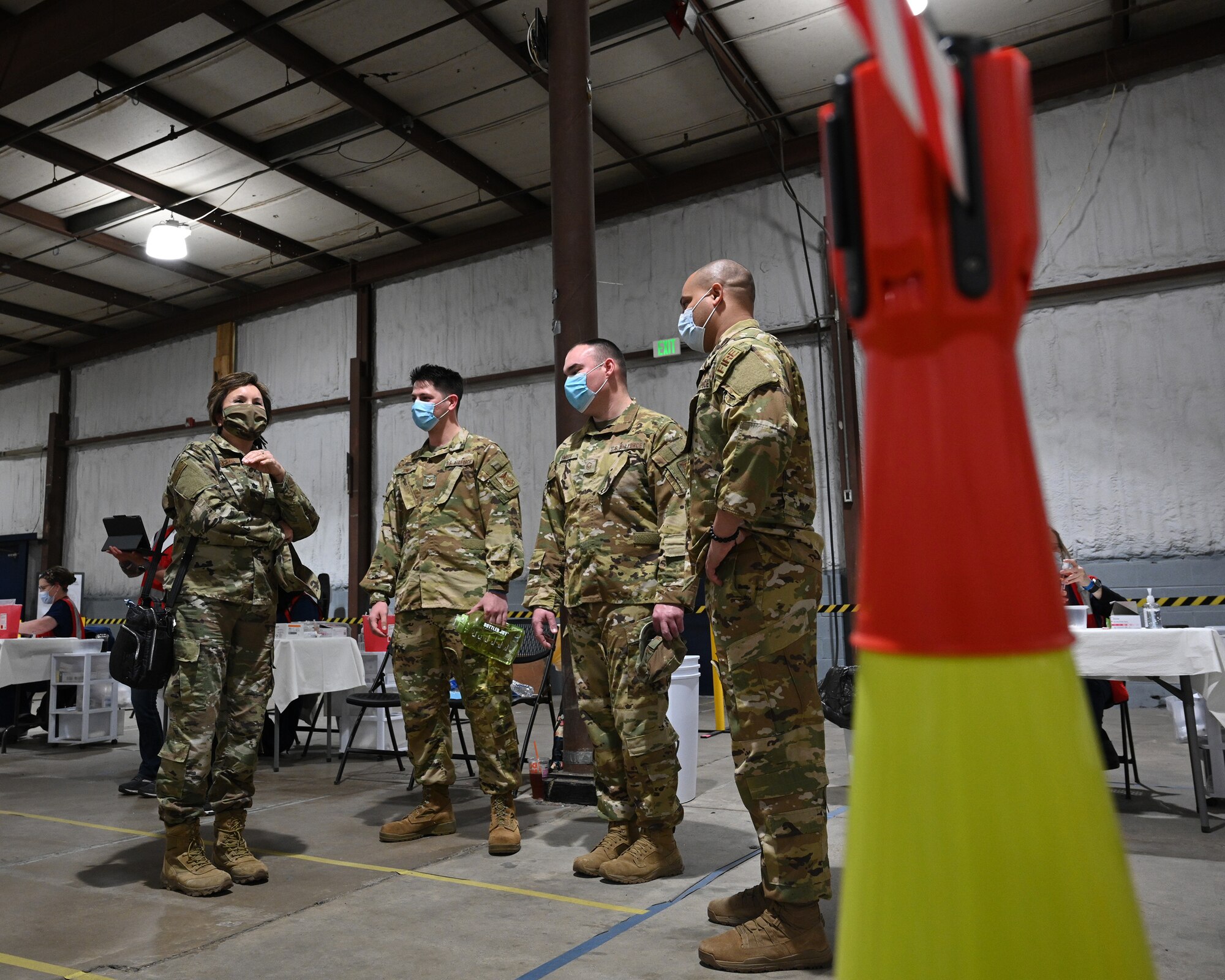 U.S. Air Force Lt. Col. Christine Estacion (left), health services administrator assigned to the 175th Medical Group, speaks with firefighters assigned to the 175th Civil Engineer Squadron, at the COVID-19 mass vaccination site at the Maryland State Fairgrounds in Timonium, Md., April 15, 2021.