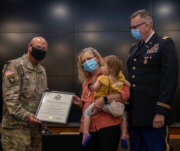 Krista Legler (center), wife of Illinois Army National Guard Lt. Col. Michael Legler (right), of Pekin, Illinois, receives a Certificate of Appreciation from Maj. Gen. Michael Zerbonia, of Chatham, Illinois, Assistant Adjutant General – Army