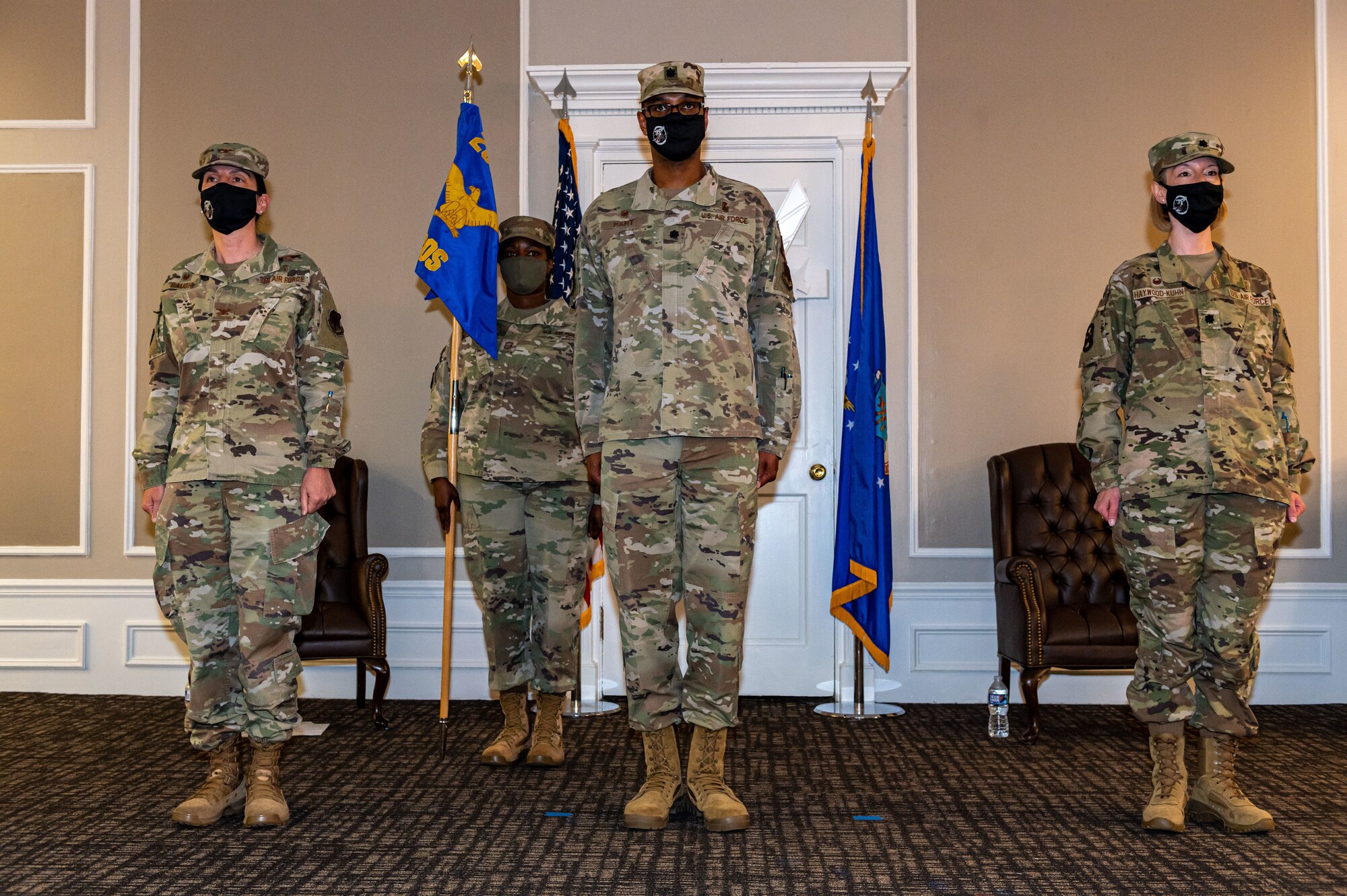 A photo of Airmen standing with a flag.