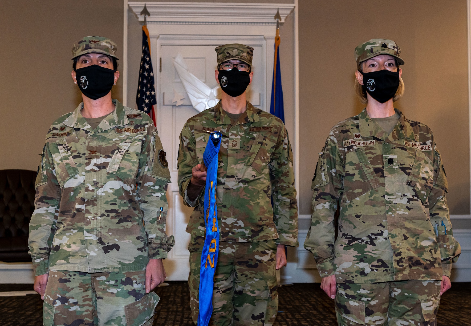 A photo of Airmen standing with a flag.