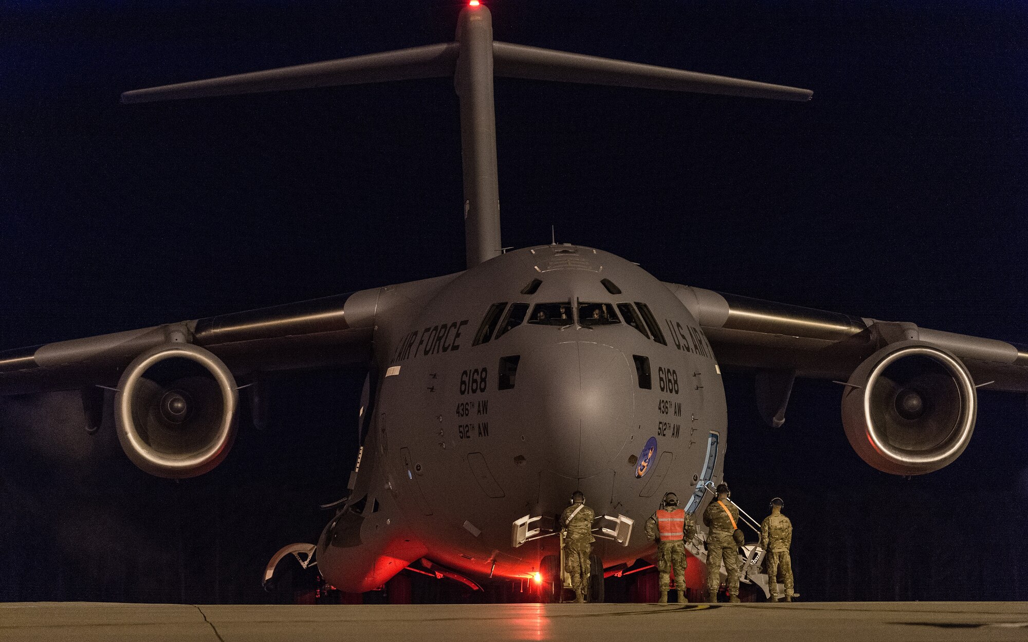 Members of the 736th Aircraft Maintenance Squadron and 3rd Airlift Squadron, stand at the nose of a C-17 Globemaster III during engine startup at Dover Air Force Base, Delaware, April 23, 2021. The C-17 is the most flexible cargo aircraft in the entire Air Force fleet, capable of rapid strategic delivery of troops and cargo to locations around the world. (U.S. Air Force photo by Roland Balik)