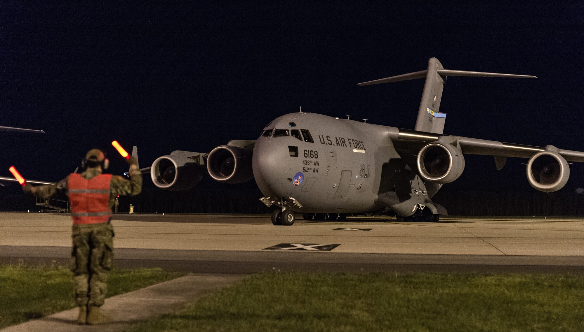Airman 1st Class Bain Adair, 736th Aircraft Maintenance Squadron integrated avionics journeyman, marshals a C-17 Globemaster III at Dover Air Force Base, Delaware, April 23, 2021. The C-17 is the most flexible cargo aircraft in the entire Air Force fleet, capable of rapid strategic delivery of troops and cargo to locations around the world. (U.S. Air Force photo by Roland Balik)