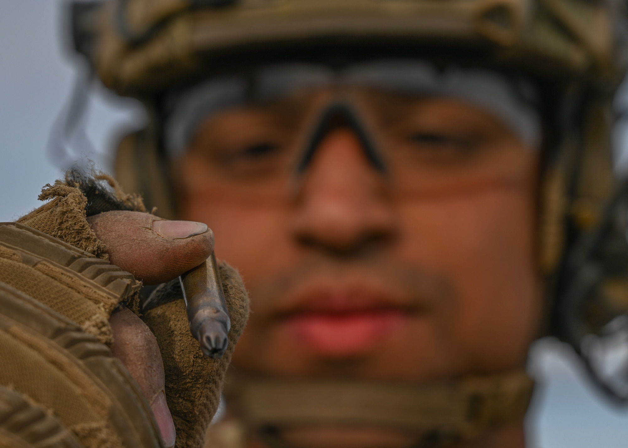 A U.S. Air Force tactical air control party Airman with the 5th Air Support Operations Squadron examines a 5.56mm ammunition blank shell at Yakima Training Center, Washington, April 28, 2021. Blank ammunition is often used by the 5th ASOS for exercise purposes. (U.S. Air Force photo by Airman 1st Class Callie Norton)