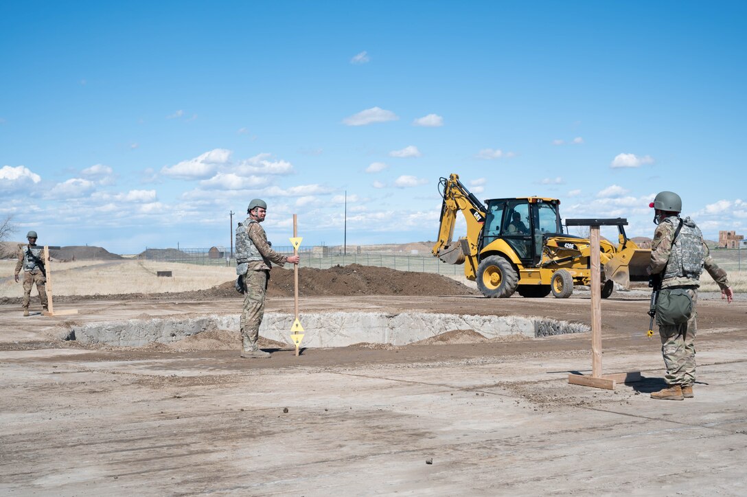 Members of the 819th RED HORSE Squadron perform crater profile measuring by looking between two triangles to check whether the crater is level May 3, 2021, at Malmstrom Air Force Base, Mont.