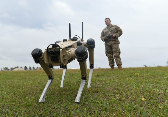 An airman operates a robotic dog.