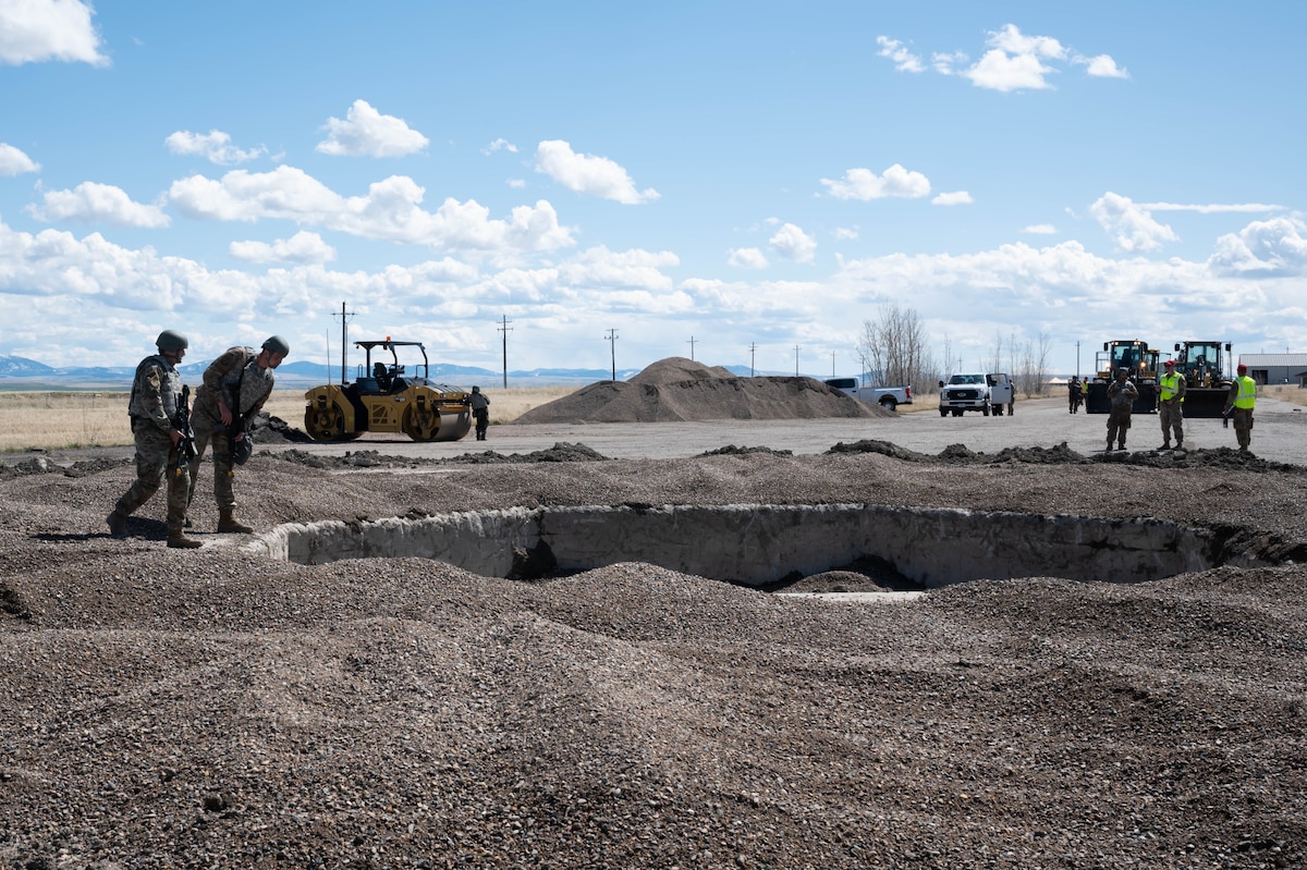 Members of the 819th RED HORSE Squadron inspect a crater after a simulated mortar attack during an exercise May 3, 2021, at Malmstrom Air Force Base.
