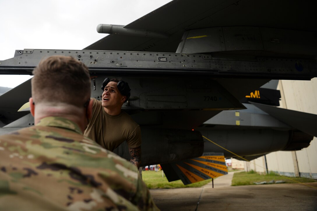 An Airman loads a munition on a jet.