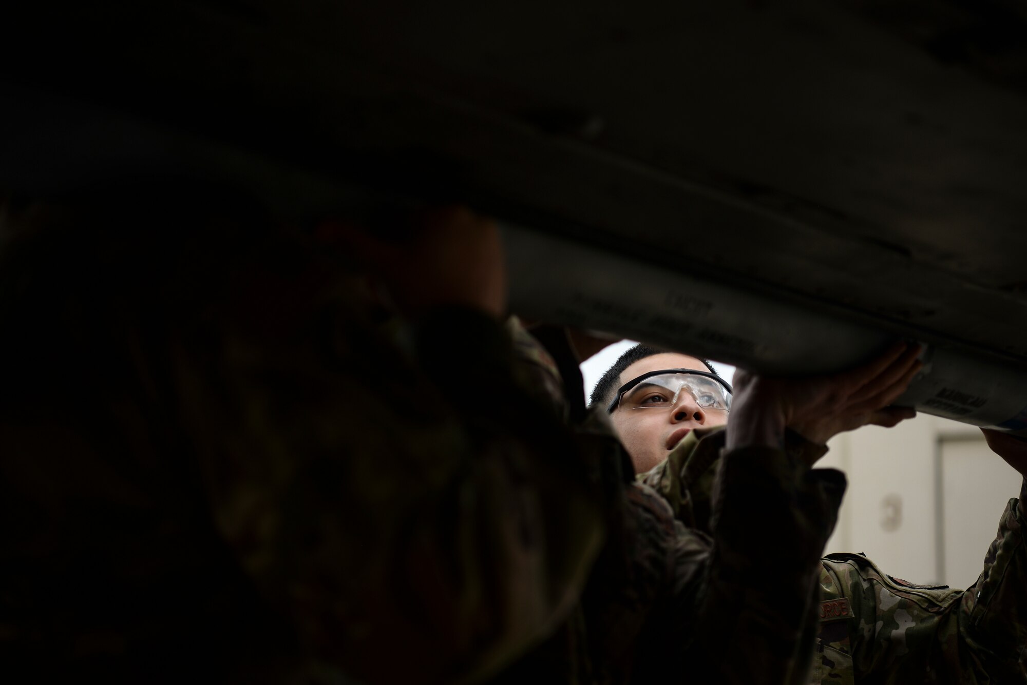 An Airman loads a munition onto an aircraft.