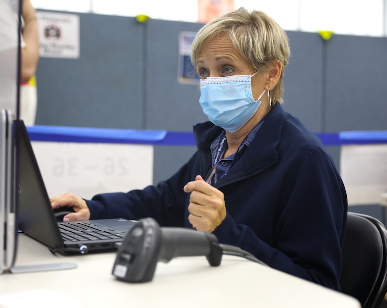 Beth Utecht, a Reemployed Annuitant with the U.S. Army Corps of Engineers, works the registration desk at the New Jersey Institute of Technology Community Vaccination Center in Newark, N.J., April 2021.