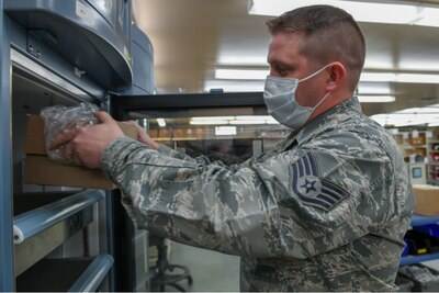 Staff Sgt. Bush Meister, 19th Medical Group NCO in charge of medical equipment, stores the first shipment of the Moderna COVID-19 Vaccine at Little Rock Air Force Base, Arkansas, Jan. 13, 2021.