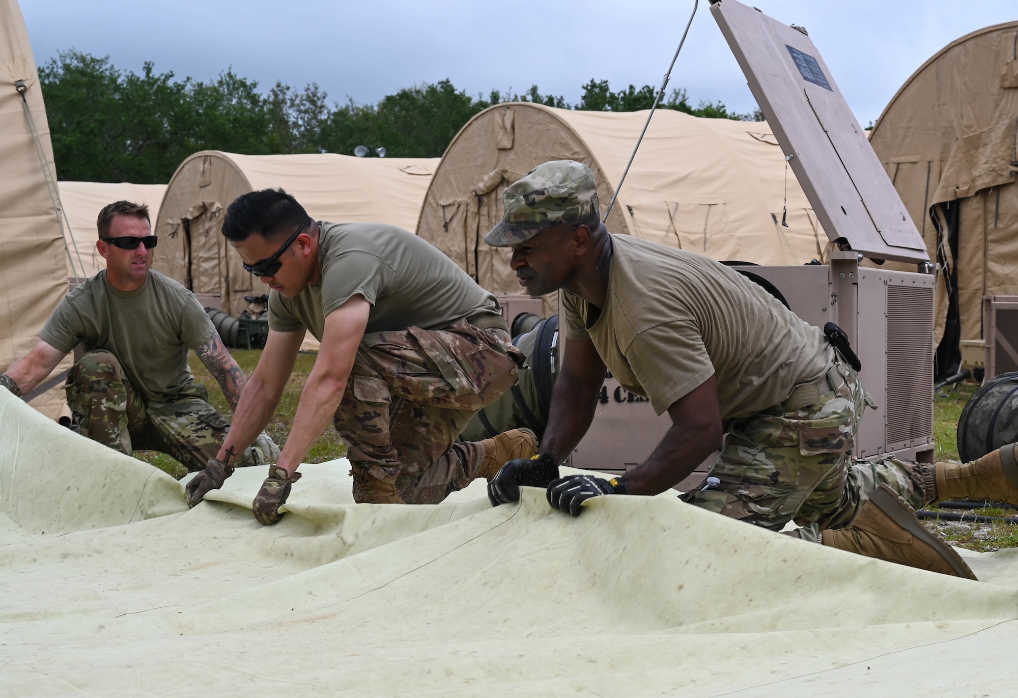 U.S. Air Force Airmen pack tents at Naval Outlying Landing Field Choctaw, Florida, May 4, 2021. The tents were used during Agile Flag 21-2, an experiment that tests a units capability to deploy and succeed in a bare base situation. (U.S. Air Force photo by Senior Airman Sarah Dowe)