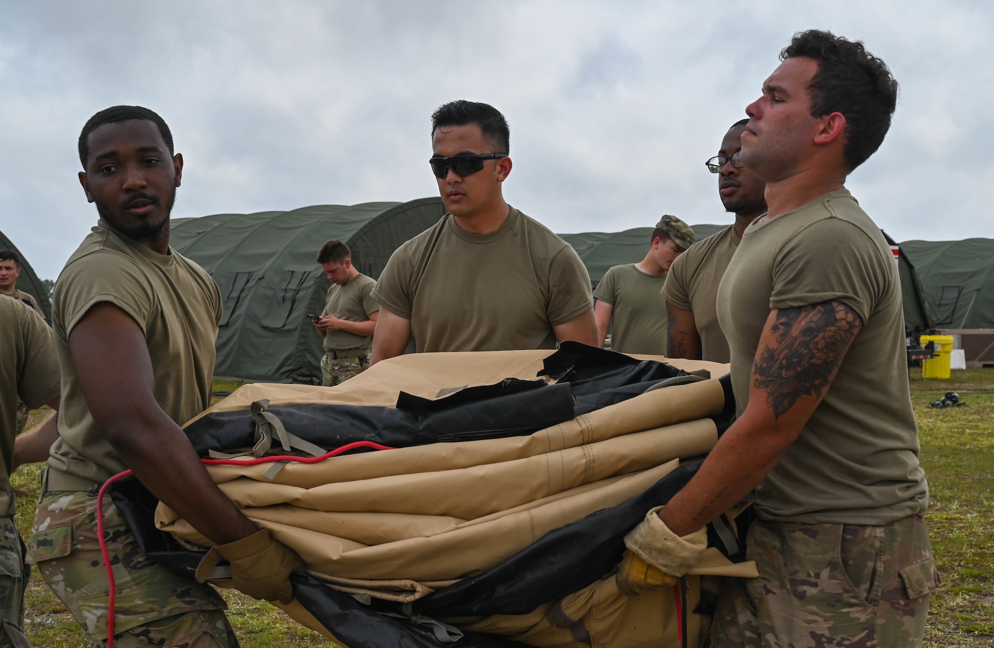 U.S. Air Force Airmen pack tents at Naval Outlying Landing Field Choctaw, Florida, May 4, 2021. The tents were used during Agile Flag 21-2, an experiment that tests a units capability to deploy and succeed in a bare base situation. (U.S. Air Force photo by Senior Airman Sarah Dowe)