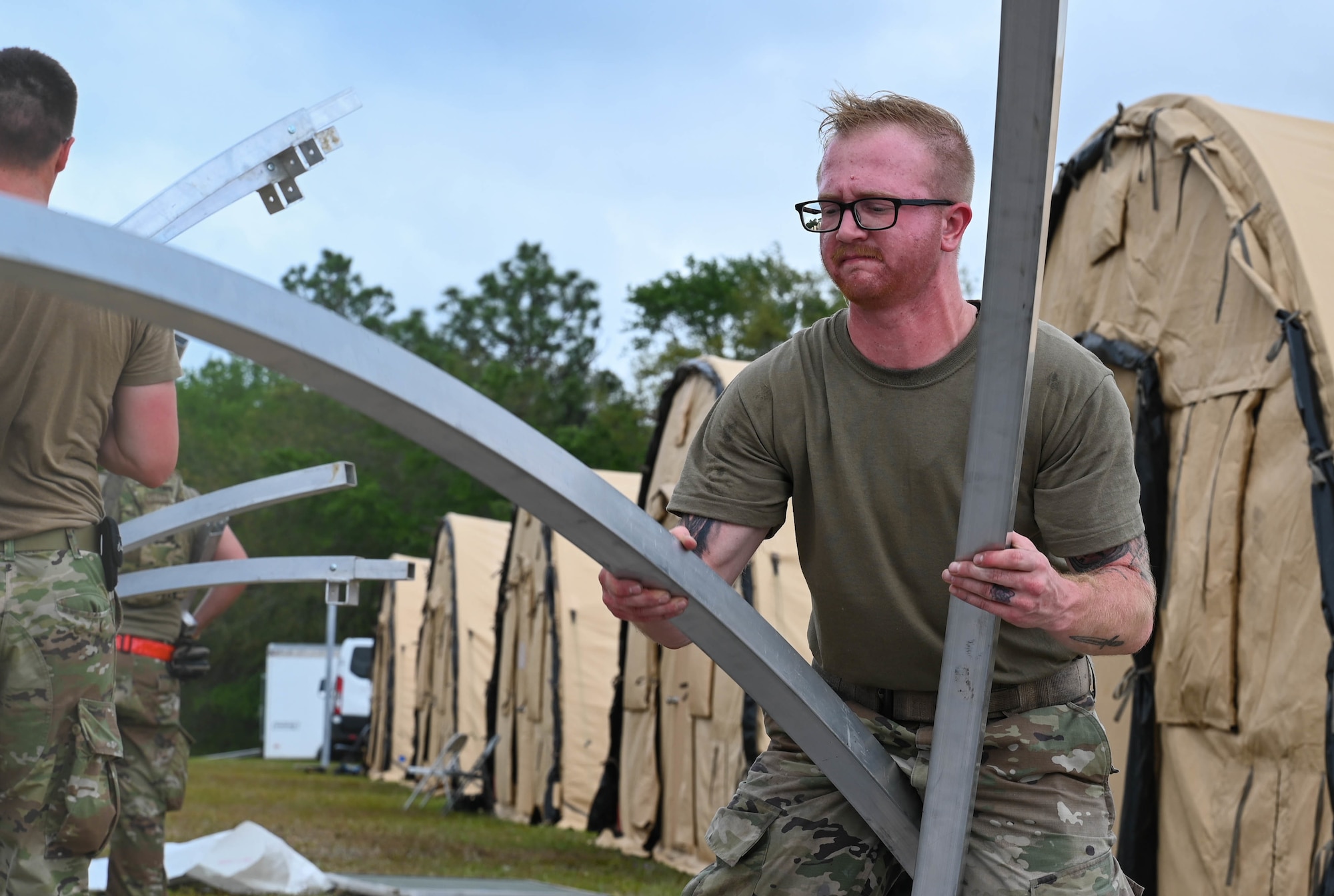 A U.S. Air Force Airman helps tear down and pack tents at Naval Outlying Landing Field Choctaw, Florida, May 4, 2021. The tents were used during Agile Flag 21-2, an experiment that tests a units capability to deploy and succeed in a bare base situation. (U.S. Air Force photo by Senior Airman Sarah Dowe)