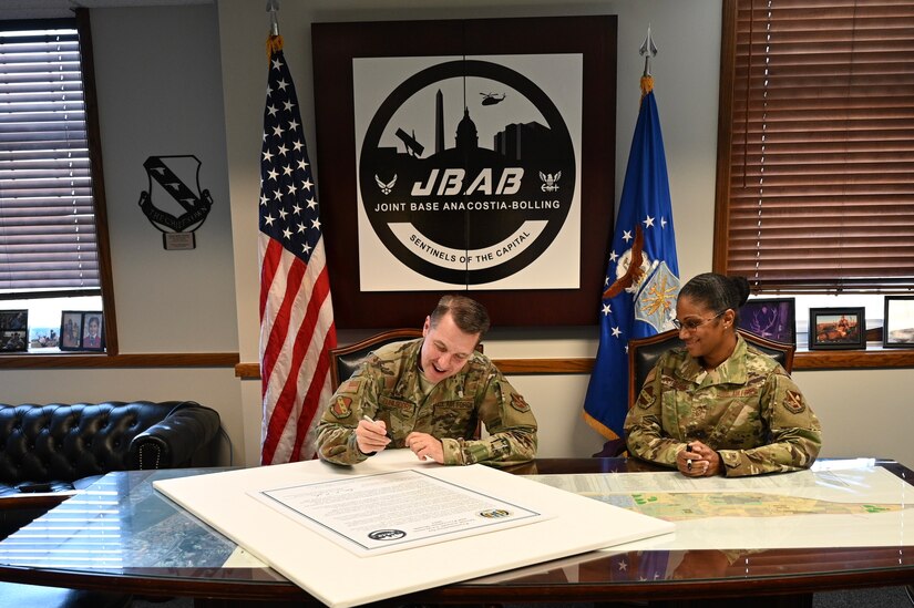 U.S. Air Force Col. Michael Zuhlsdorf, Joint Base Anacostia-Bolling and 11th Wing commander, signs the Sexual Assault Awareness and Prevention Month Proclamation as Joint Base Anacostia-Bolling Command Chief Master Sgt. Christy Peterson looks on at Joint Base Anacostia-Bolling, Washington DC, April 5, 2021. The Sexual Assault Prevention and Response team on Joint Base Anacostia-Bolling provides victim support and resources, civilian and military training, and community awareness. Sexual Assault Awareness and Prevention Month is commemorated every April, and annual events are organized by the SAPR office. This year’s events include a virtual fun run, a calendar of daily reflections, and a proclamation signed by 11WG leadership, which will travel throughout the installation where passersby may add their signatures and support. (U.S. Air Force  photo by Technical Sgt. Katie Edelman)
