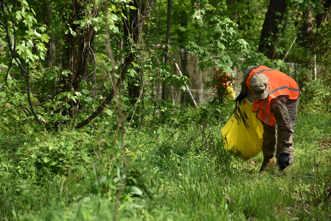 An Airman picks up trash during Earth Week, April 28, 2021, near Joint Base Andrews, Md. Earth Week 2021 events included hosting an electronics and household hazardous waste recycling location, trash clean-up on and off base, and planting trees. (U.S. Air Force photo by Senior Airman Daniel Brosam)