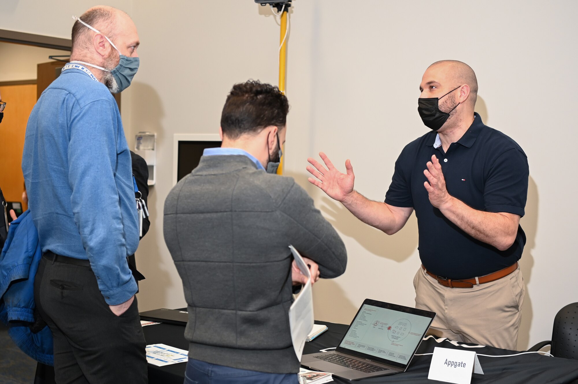 Jonathan Roy, right, AppGate Federal principal security architect, speaks to Daniel Olson, from left, and Kelvin Hernandez-Cruz, both Special Programs Division engineers, during the Lantern Spring Demo Days at Hanscom Air Force Base, Mass., May 5.