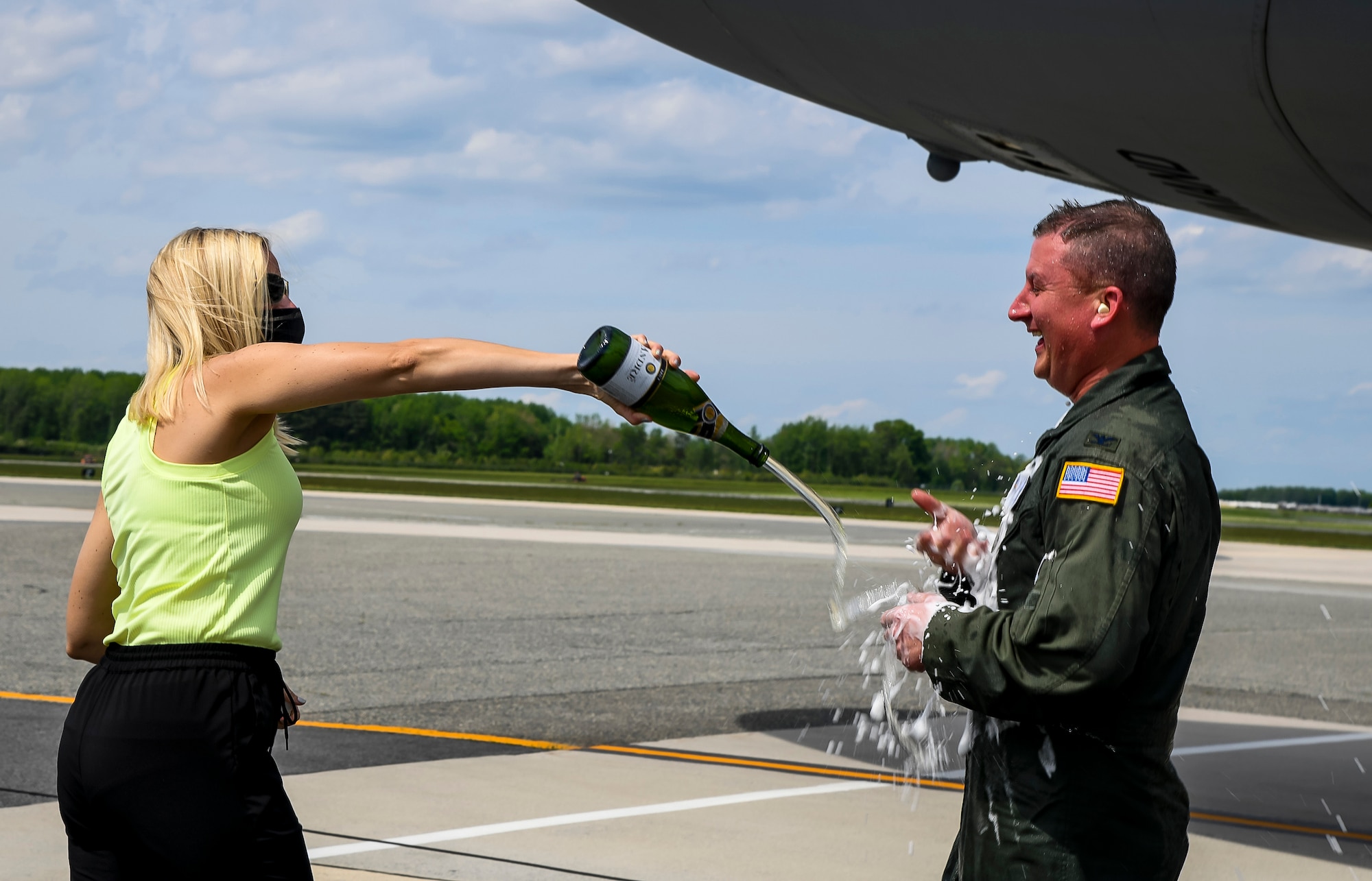 Christie Jones pours champagne on her husband, Col. Matthew Jones, 436th Airlift Wing commander, following his fini flight at Dover Air Force Base, Delaware, May 4, 2021. A “fini flight” is an Air Force tradition where an Airman and their family celebrate their final flight. (U.S. Air Force photo by Airman 1st Class Stephani Barge)