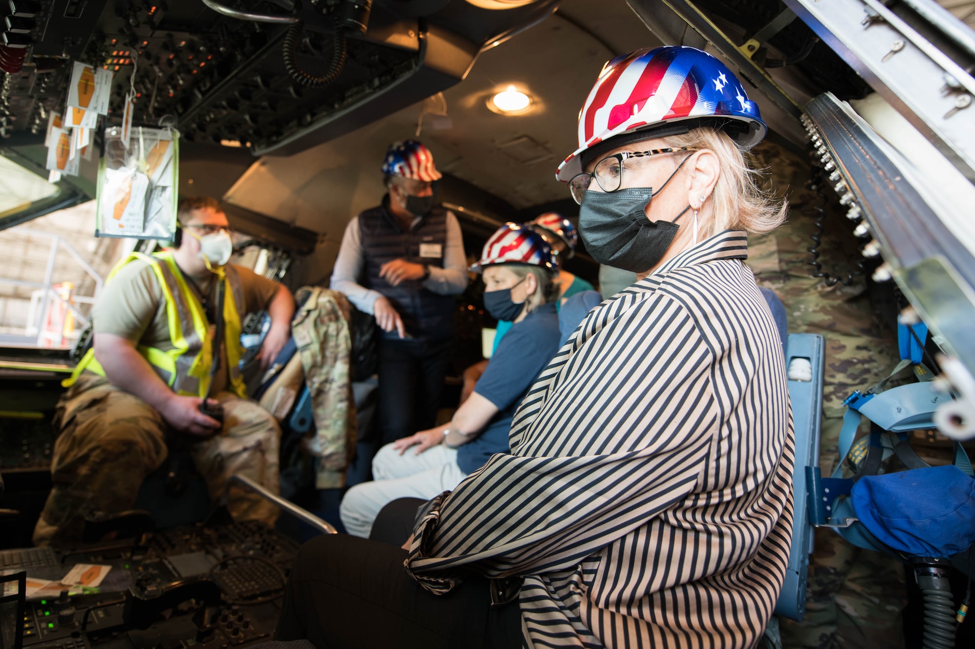 Honorary commanders from Travis Air Force Base, California, sit in the flight deck of a C-5M Super Galaxy at the Isochronal Inspection Dock on Dover AFB, Delaware, May 4, 2021. Although Travis AFB has its own fleet of C-5Ms, the ISO dock at Dover AFB is the maintenance dock in the Air Force that performs certain major inspections of C-5M aircraft. (U.S. Air Force photo by Mauricio Campino)