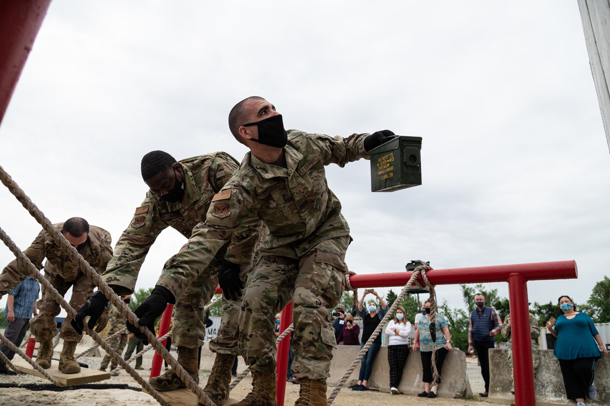 Staff Sgt. Zachary Huffman, Tactics and Leadership Nexus (TALN) instructor, prepares to hand off an ammunition canister at Dover Air Force Base, Delaware, May 5, 2021. Instructors from TALN gave honorary commanders from Travis AFB, California, a demonstration on leadership tactics used during a short obstacle course. (U.S. Air Force photo by Senior Airman Marco A. Gomez)