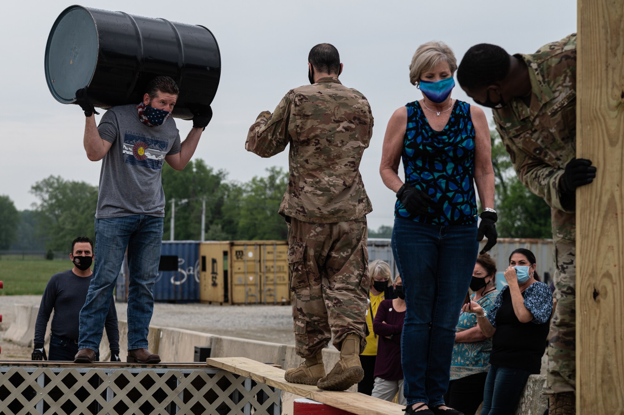 A team of Tactics and Leadership Nexus (TALN) instructors and honorary commanders from Travis Air Force Base, California, work together to cross an obstacle course at Dover AFB, Delaware, May 5, 2021. The honorary commanders participated in demonstrations conducted by members of TALN. (U.S. Air Force photo by Senior Airman Marco A. Gomez)