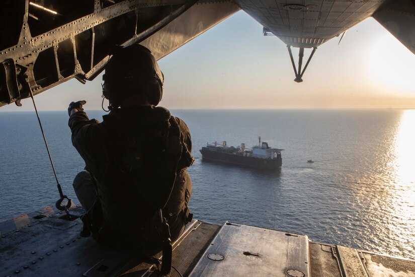 A Marine looks out from the ramp of a helicopter.