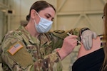 Specialist Jennifer Phillips, a combat medic with the Michigan Army National Guard’s Task Force Red Lion COVID-19 vaccination/testing team, administers the vaccination to employees and their families during a walk-in clinic for the Army Tank-Automotive and Armaments Command in Warren, Michigan, April 28, 2021.