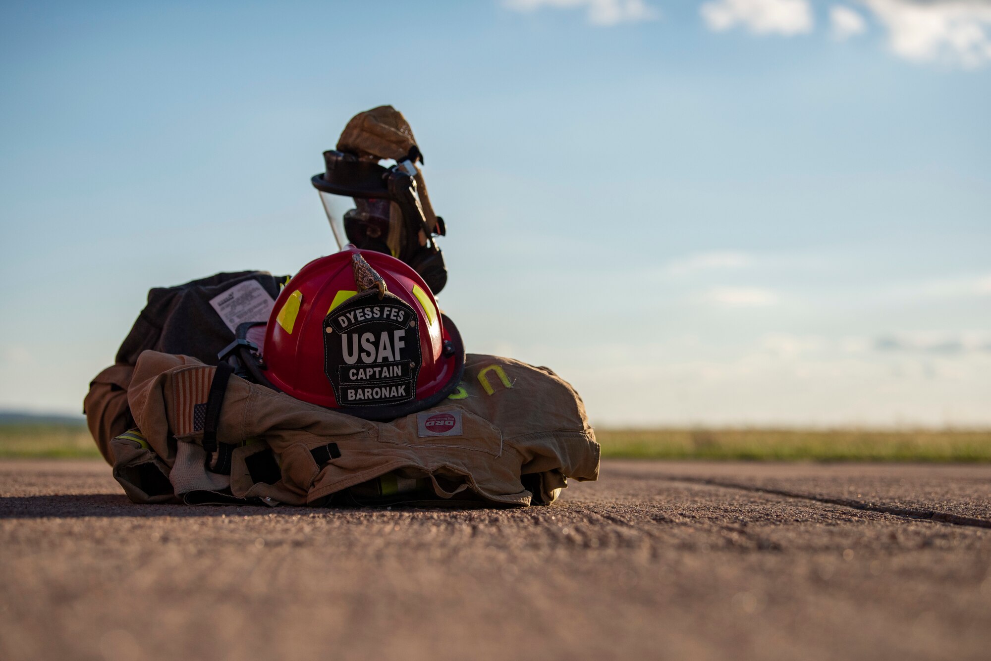 Firefighter protective equipment sits on the concrete at an aircraft fire training pit at Dyess Air Force Base, Texas, May 4, 2021. Firefighter protective equipment helps protect firefighters from heat, flames and smoke while combating large fires. (U.S. Air Force photo by Airman 1st Class Colin Hollowell)