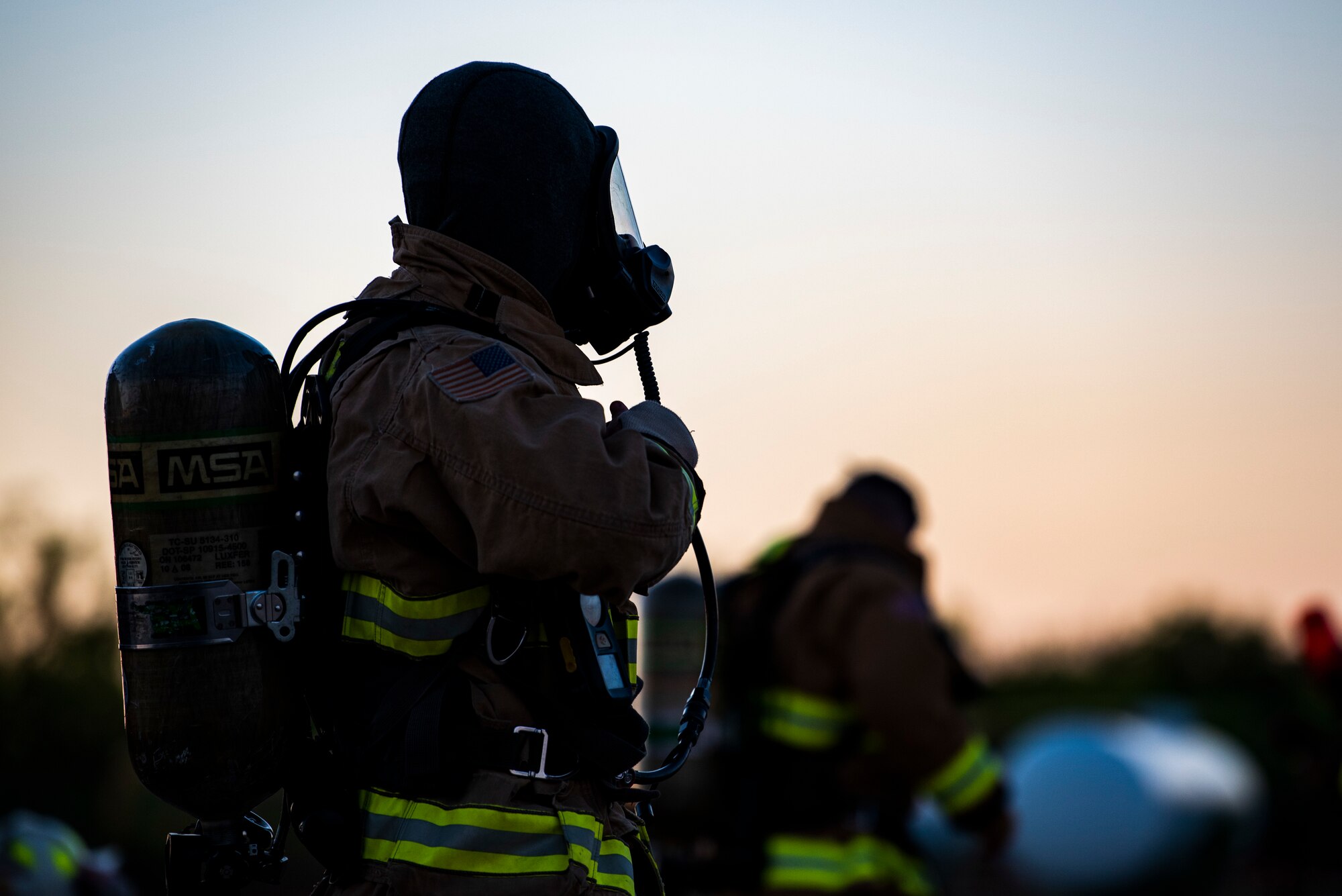 Firefighters assigned to the 7th Civil Engineer Squadron and 512th CES, dawn fire protective gear before conducting nighttime aircraft fire training at Dyess Air Force Base, Texas, May 4, 2021. The 7th CES firefighters routinely conduct training to enhance safety and proficiency while fighting fires. (U.S. Air Force photo by Airman 1st Class Colin Hollowell)