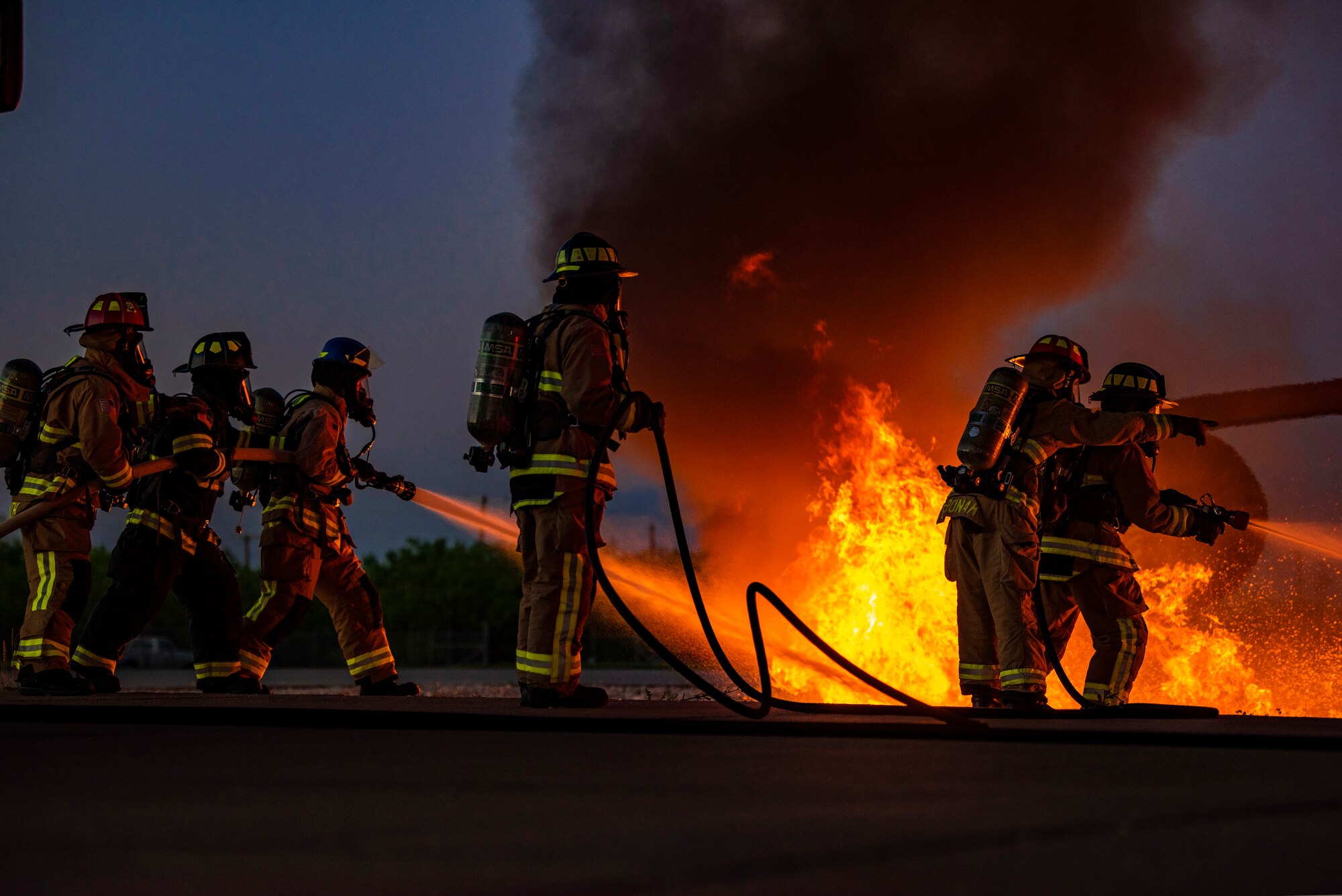 Firefighters assigned to the 7th Civil Engineer Squadron and 512th CES extinguish flames during an aircraft fire training at Dyess Air Force Base, Texas, May 4, 2021. Firefighters assigned to the 7th and 512th CES conducted the live fire training with firefighters from the Abilene Regional Airport’s aircraft rescue team to enhance safety, proficiency and interoperability. (U.S. Air Force photo by Airman 1st Class Colin Hollowell)