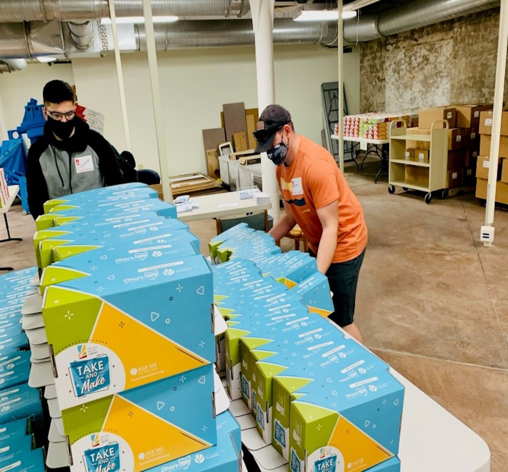 Senior Airman Alexander Otto (left) and Tech Sgt. Stephen Parson organize assembled kits. The “Take and Make” kits the team packed and arranged support