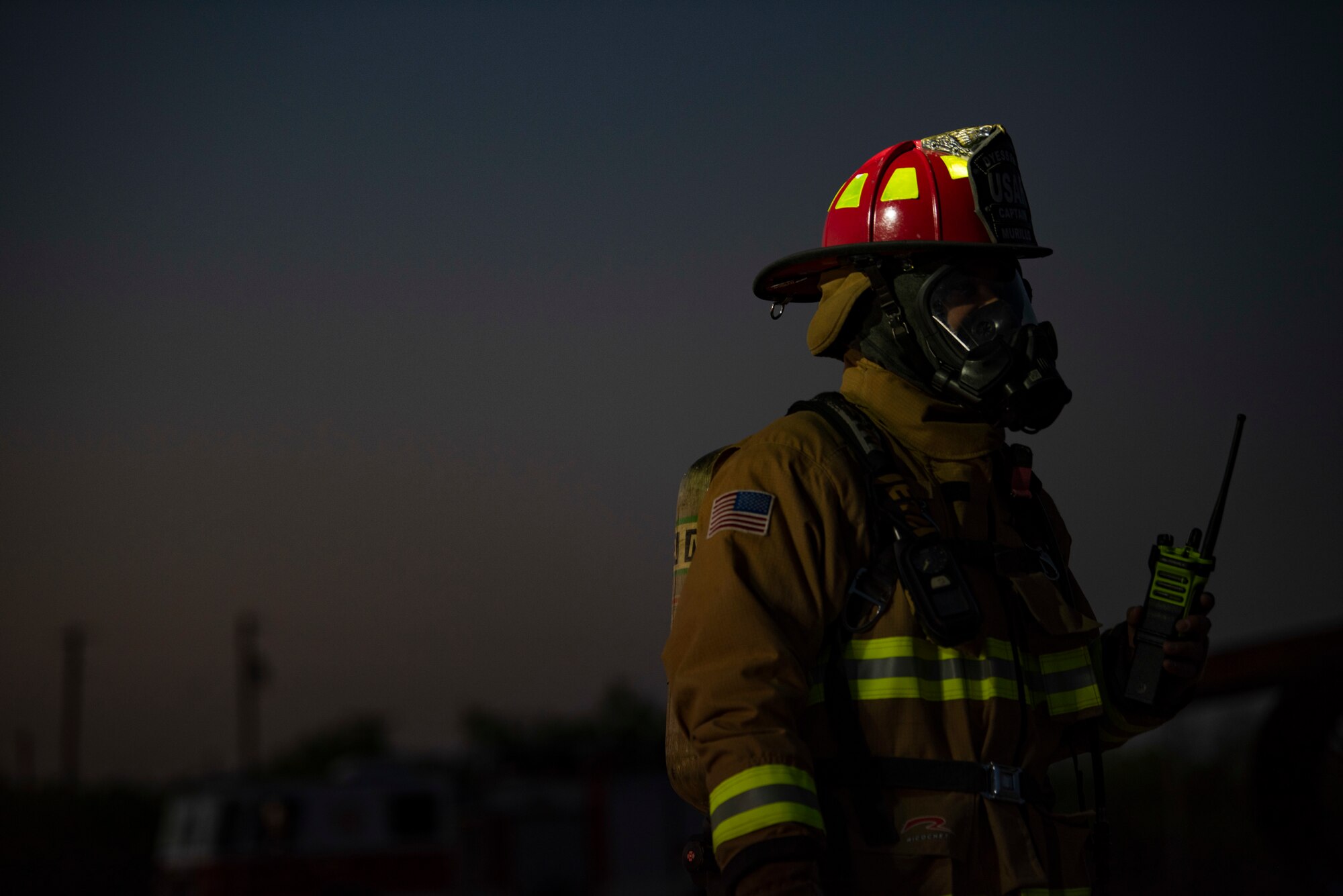 A firefighter assigned to the 7th Civil Engineer Squadron oversees a nighttime aircraft fire training at Dyess Air Force Base, Texas, May 4, 2021. Conducting the aircraft fire training at night tested the firefighters ability to safely combat fires while operating in low-light conditions, enhancing the readiness necessary to respond to fire emergencies 24 hours a day. (U.S. Air Force photo by Airman 1st Class Colin Hollowell)