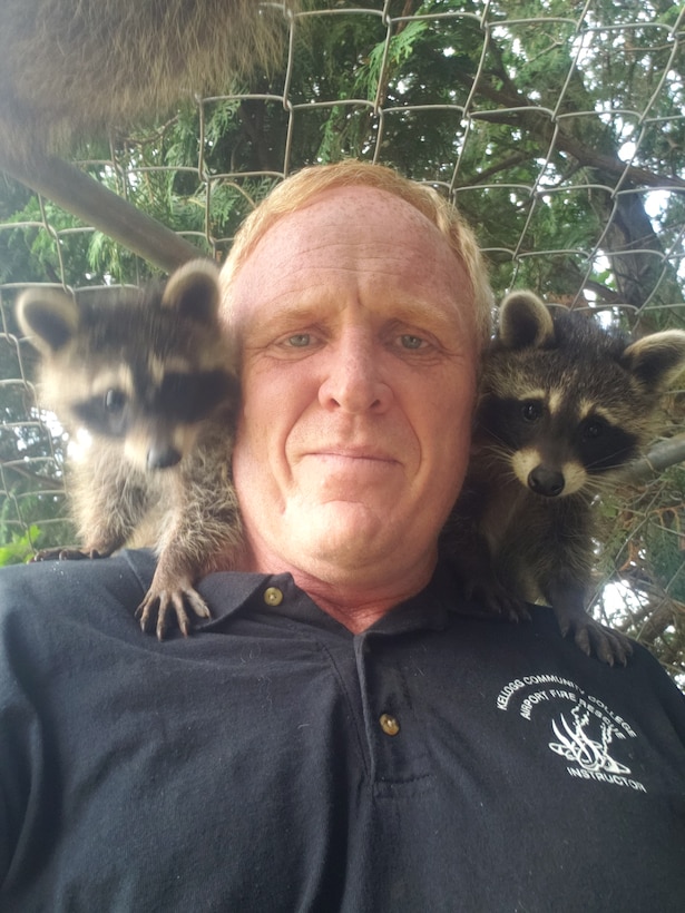 Man with two raccoons on his shoulders