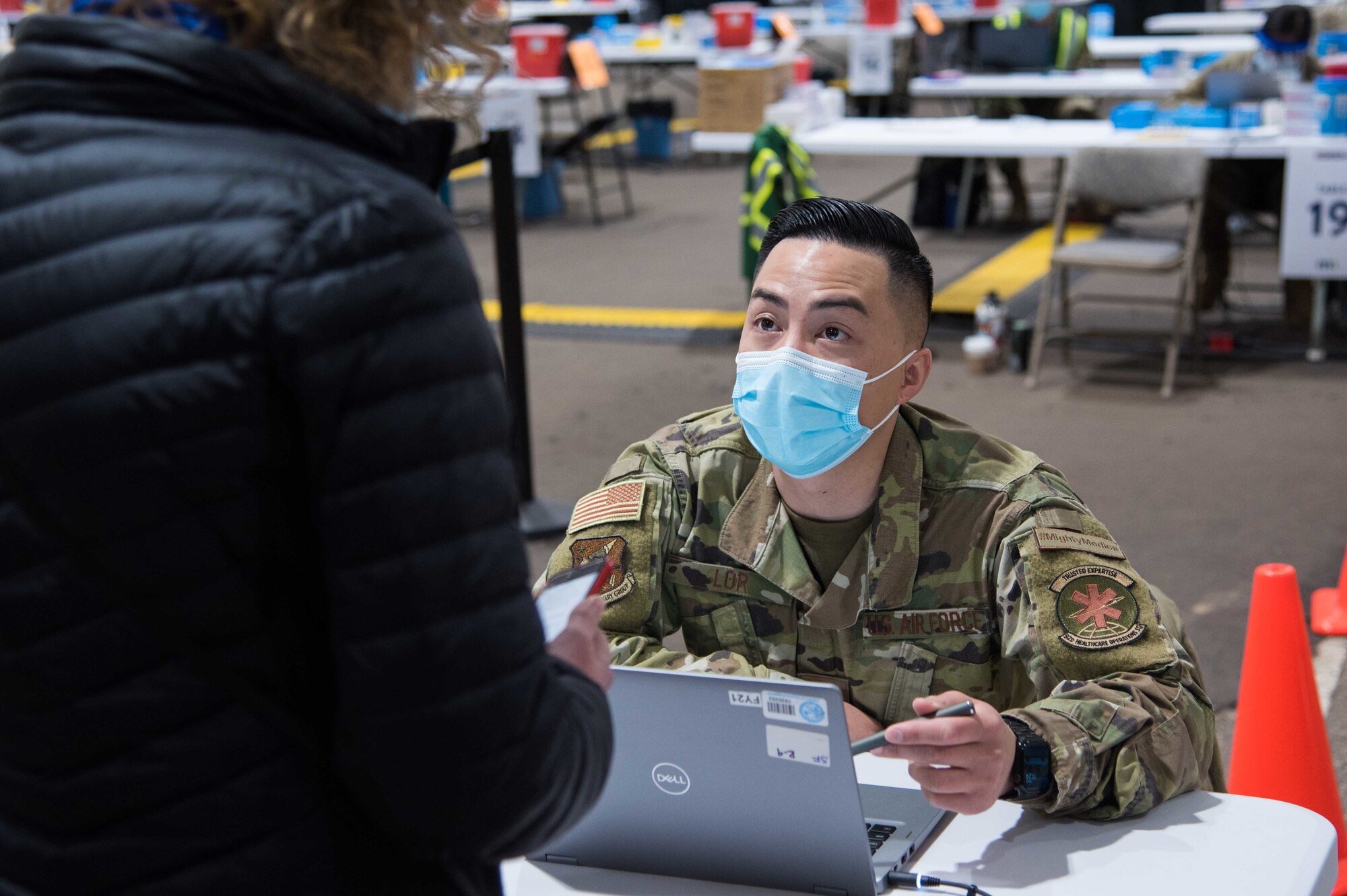 U.S. Air Force Senior Airman Peter Lor, 92nd Medical Group pharmacy technician, collects a community member’s information before a COVID-19 vaccine is administered