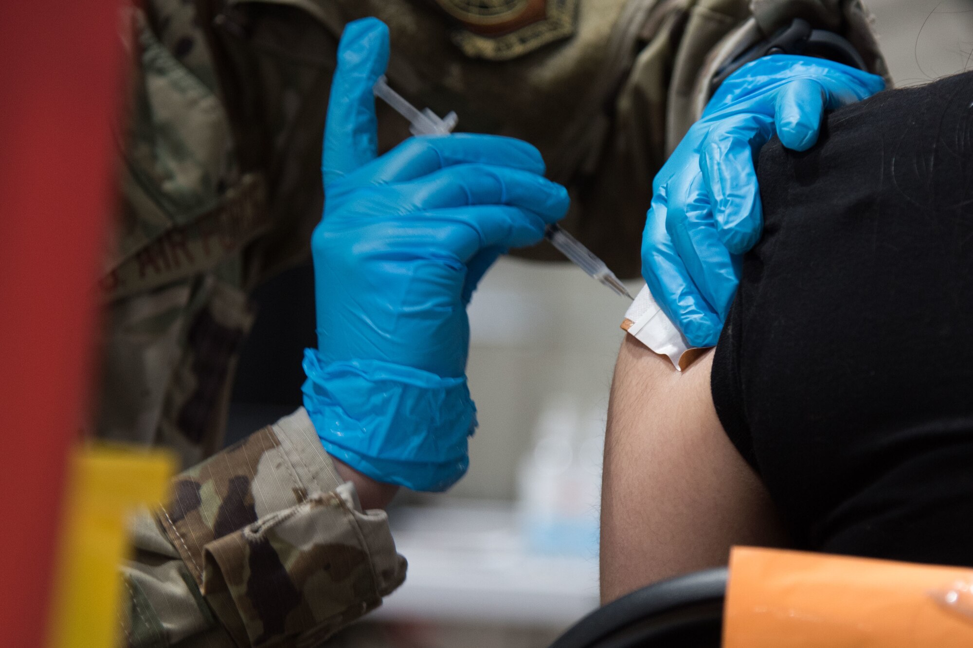 U.S. Air Force Senior Airman Daschia Lawrence, 92nd Healthcare Operation Squadron medical technician, administers a COVID-19 vaccine to a community member