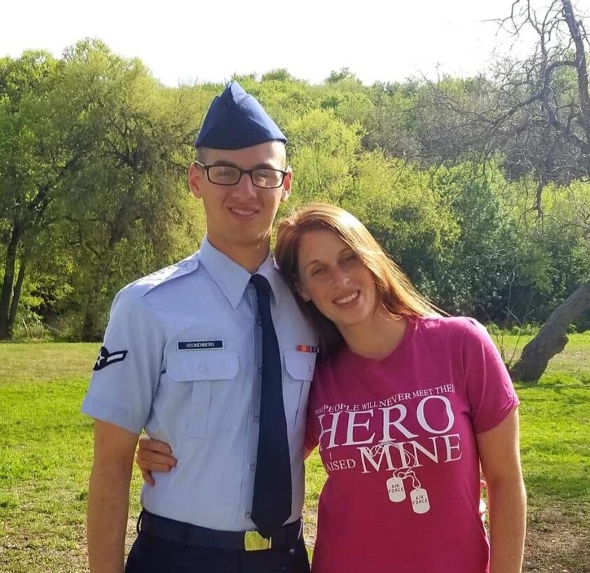 Mother hugs Airman in dress blues in a park.