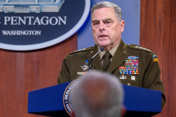 A man in a military uniform speaks to a group.