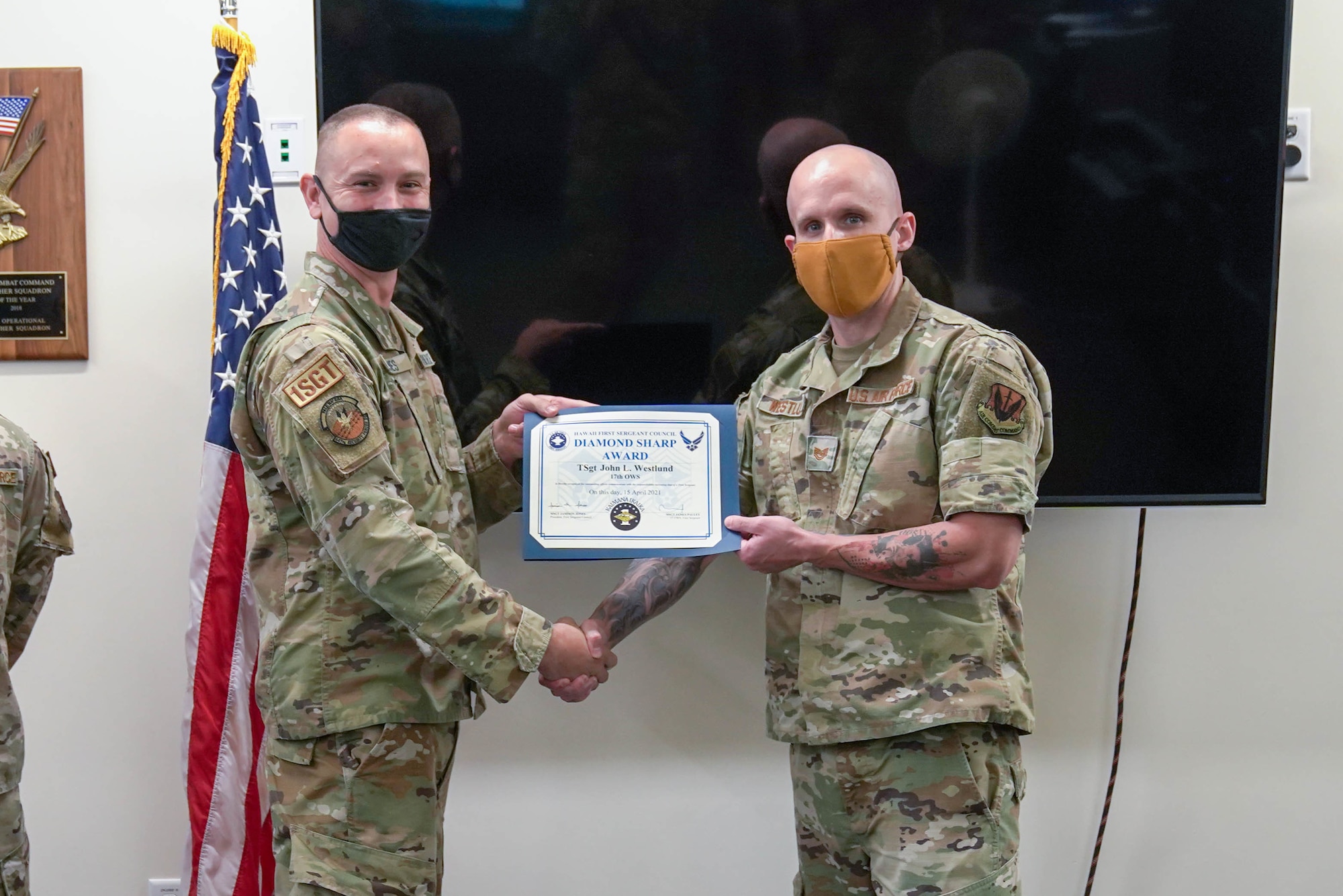 Master Sgt. Jamison Jones, 647th Security Forces Squadron first sergeant, presents the Diamond Sharp award to Tech. Sgt. John Westlund, 17th Operational Weather Squadron weather craftsman, at Joint Base Pearl Harbor-Hickam, Hawaii, April 19, 2021. Westlund was nominated by his First Sergeant and received the award for going above and beyond and demonstrating first sergeant qualities for helping out a fellow Airman in need. (U.S. Air Force photo by Airman 1st Class Makensie Cooper)