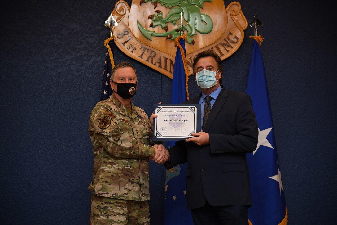 U.S. Air Force Lt. Gen. Marshall B. Webb, commander of Air Education Training Command, presents the iChallenge fourth place Torch Award to Dr. Jerry Coats, AETC/A9 Analysis and Innovation Directorate deputy director, during the iExpo award ceremony inside the Bay Breeze Event Center at Keesler Air Force Base, Mississippi, May 6, 2021. The iChallenge was created to help inspire personnel around AETC to create new and innovative ways of completing the Air Force mission. Air Force Chief of Staff Gen. Charles Q. Brown, Jr., put in place the Accelerate Change or Lose strategic approach in August 2020 to recognize the rapidly changing technology in the world and to encourage positive change in the Air and Space Forces. This action order has helped shape ideas presented during this year's iChallenge. (U.S. Air Force photo by Kemberly Groue)