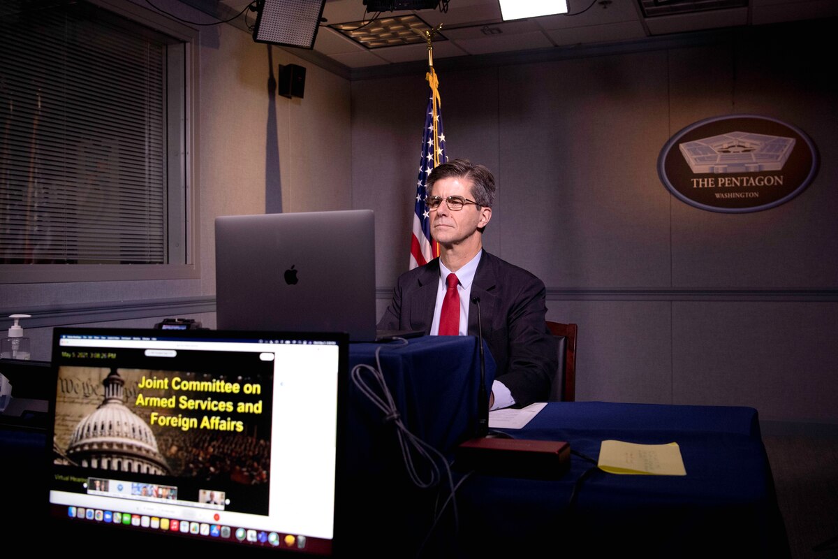 A man sits in front of a laptop computer.