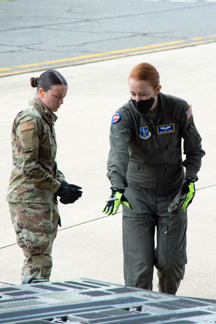Airman 1st Class Leah Brasure, air transportation specialist, and Staff Sgt. Becky Campos, loadmaster, prepare cargo to be loaded on a C-17 Globemaster III. The 167th and 166th Airlift Wings partnered together to conduct a joint cargo loading exercise as part of the 166th's home station operational readiness exercise May 3 at New Castle Air National Guard Base, Delaware.