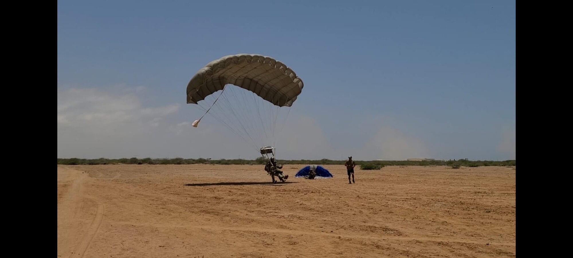 Chief Master Sergeant Luke Naughton, a pararescueman for the 82nd Expeditionary Rescue Squadron performs a jump on April 21, 2021  at Camp Lemonnier, Djibouti. Naughton conducted a jump with a backpack full of canvases of roses attached to raise awareness for cystic fibrosis. (Courtesy photo from Technical Sergeant Victor Otero)