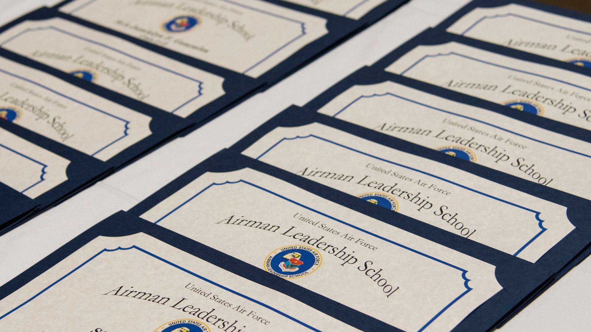 Diplomas from the Chief Master Sgt. Aubert E. Dozier Airman Leadership School are displayed on a table at a graduation ceremony, May 6, 2021, at MacDill Air Force Base, Florida.