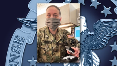 A soldier wearing a mask holds a small temperature monitor in one hand, formatted in a vertical portrait over a DLA emblem background