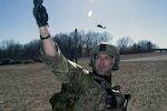 Senior Airman Ivan Villavicencio, of the 104th Security Forces Squadron, signals to responders as a medical helicopter approaches during a joint training exercise between the Massachusetts Air and Army National Guard on March 12, 2021, at Barnes Air National Guard Base, Mass.