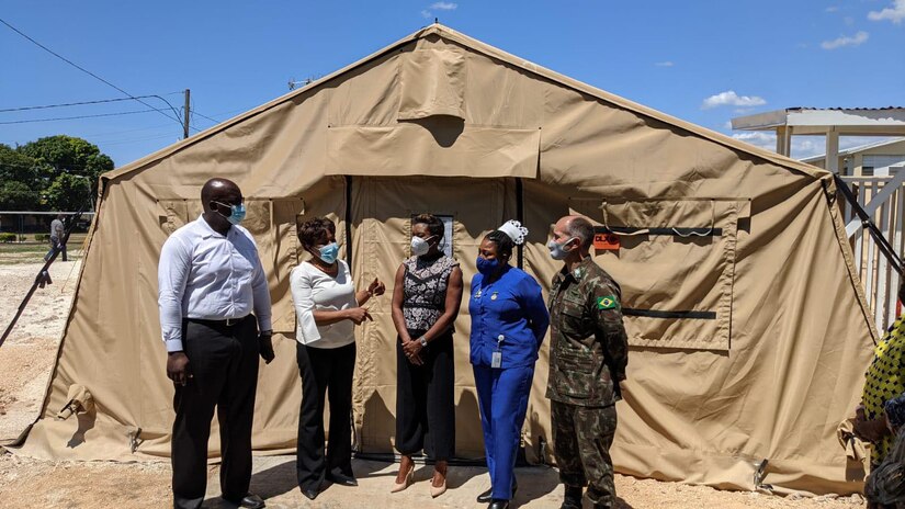 Brig. Gen. Alcides V. Faria, right, U.S. Army South deputy commanding general for interoperability, receives a tour by representatives of the Ministry of Health and Wellness of a U.S.-funded mobile field hospital based at the Spanish Town Hospital in St. Catherine, Jamaica, April 29, 2021.