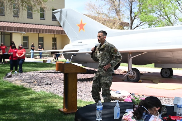 Col. George Sefzik is speaking to a crowd outdoors.