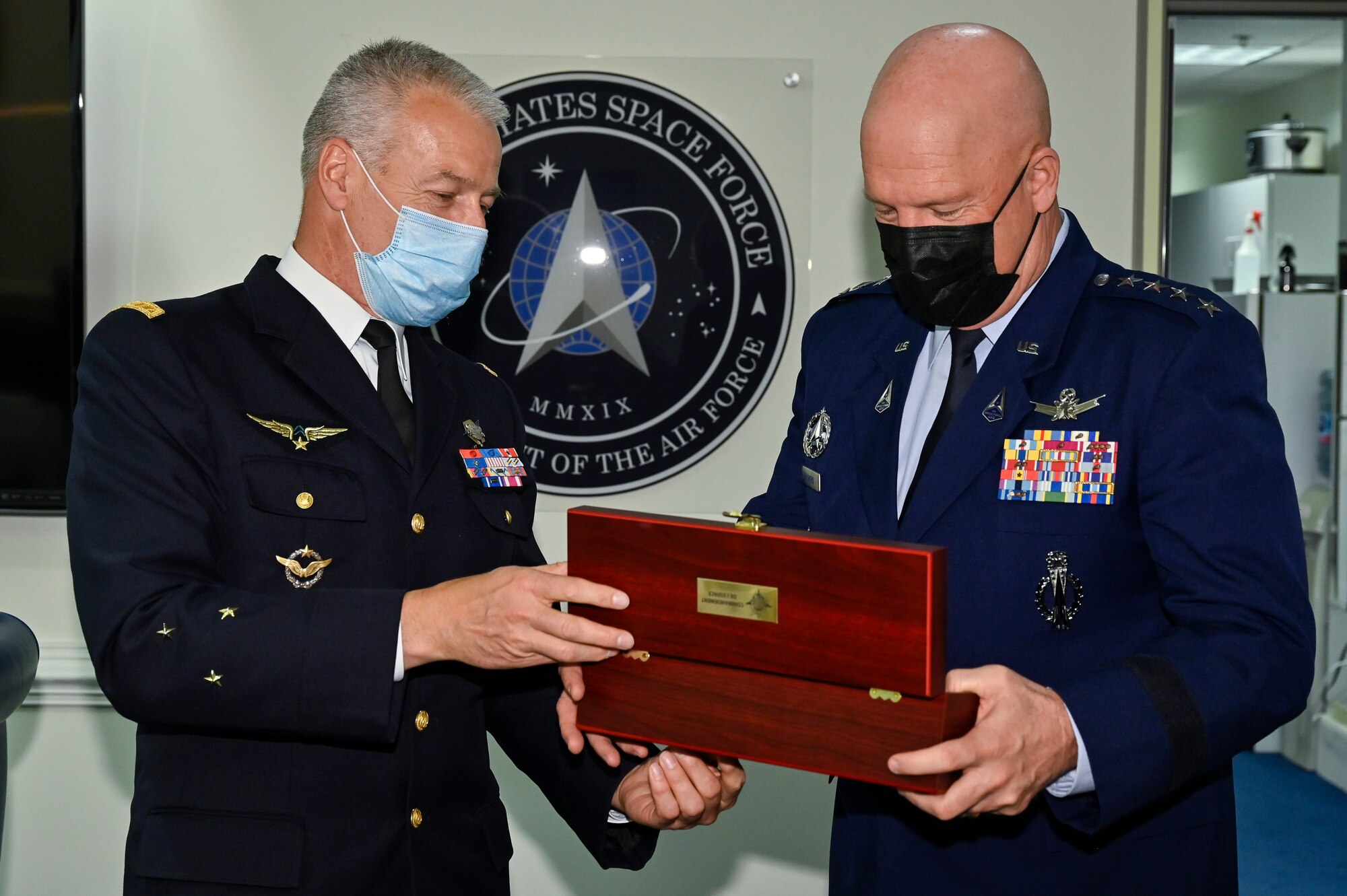 Chief of Space Operations Gen. John W. Raymond opens a gift from Maj. Gen. Michel Friedling