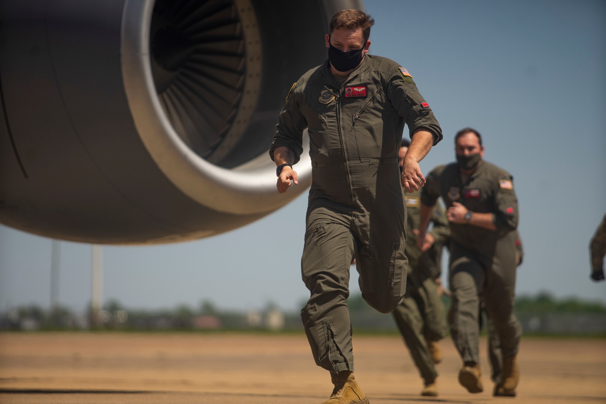 U.S. Air Force Senior Airman Seth Amiott, a 50th Air Refueling Squadron boom operator, followed by crew members, runs toward a KC-135 Stratotanker aircraft during a simulated alert scenario April 21, 2021, at Barksdale Air Force Base, Louisiana. The crew executed an alert drill during an integrated training event, meant to test timing and efficiency in an emergency takeoff scenario.