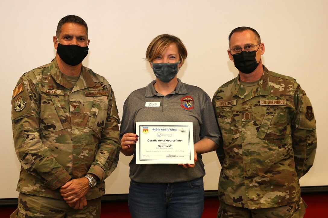 Mrs. Marcy Gantt is presented a Key Spouse Certificate of Appreciation by Col. Raymond Smith, Jr., 445th Airlift Wing commander, and Chief Master Sgt. Christopher Williams, 445th AW Command Chief Master Sgt., during the 445th Airlift Wing Key Spouse Appreciation Day May 2, 2021. The spouses were treated to breakfast and C-17 Globemaster III tour. The Key Spouse Program is an official Air Force commander's program that promotes partnerships with unit leadership, volunteer Key Spouses appointed by the commander, families, Airman & Family Readiness Center and other community and helping agencies. (U.S. Air Force photo/Tech. Sgt. Joel McCullough)