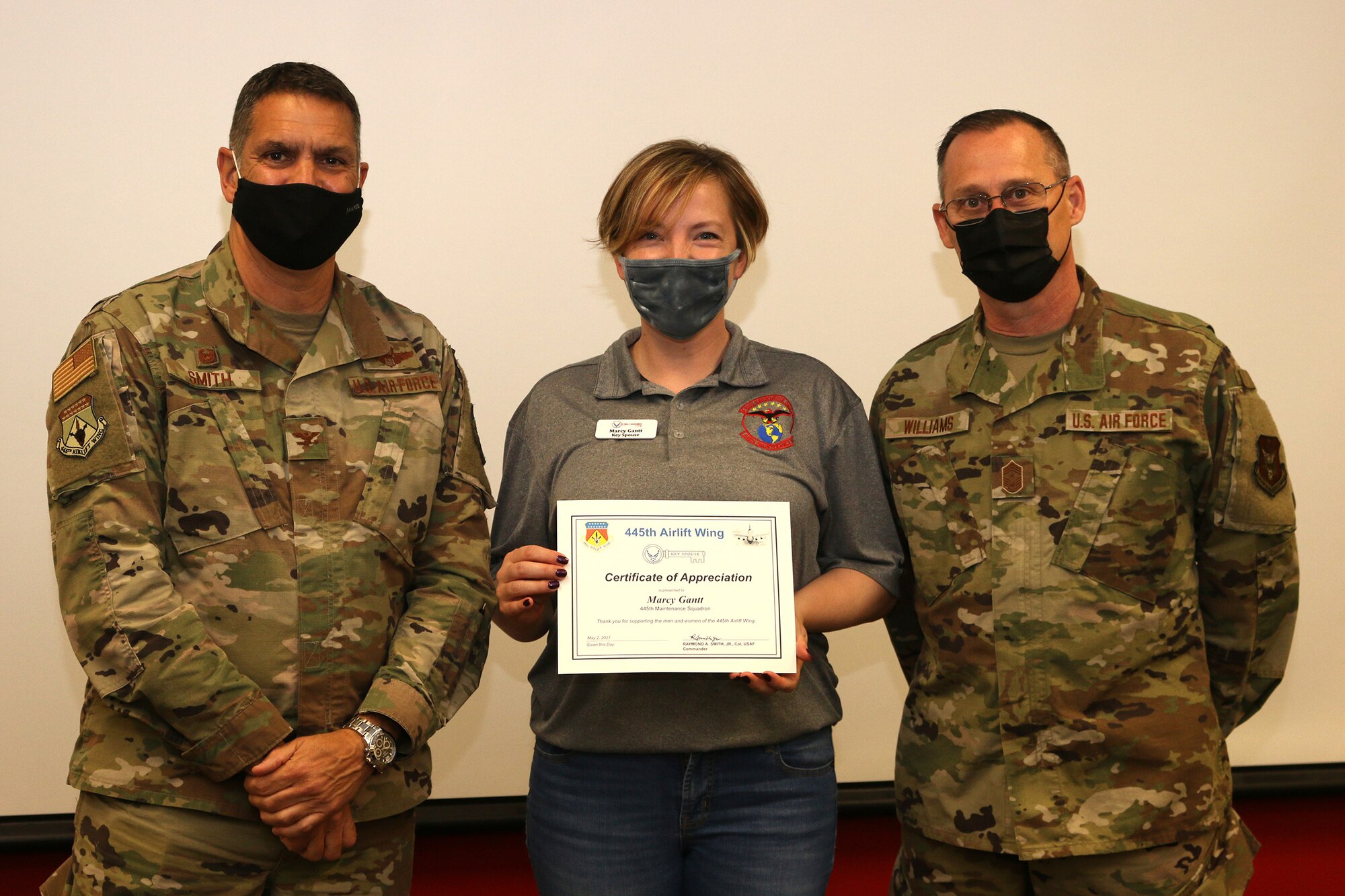 Mrs. Marcy Gantt is presented a Key Spouse Certificate of Appreciation by Col. Raymond Smith, Jr., 445th Airlift Wing commander, and Chief Master Sgt. Christopher Williams, 445th AW Command Chief Master Sgt., during the 445th Airlift Wing Key Spouse Appreciation Day May 2, 2021. The spouses were treated to breakfast and C-17 Globemaster III tour. The Key Spouse Program is an official Air Force commander's program that promotes partnerships with unit leadership, volunteer Key Spouses appointed by the commander, families, Airman & Family Readiness Center and other community and helping agencies. (U.S. Air Force photo/Tech. Sgt. Joel McCullough)